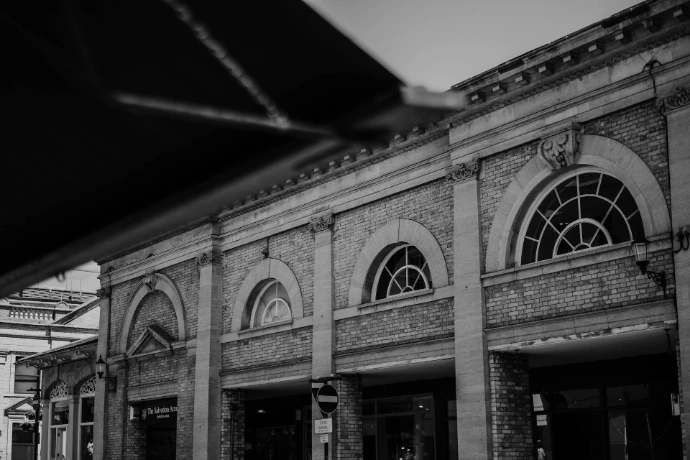Black and white brick building with arched windows.